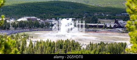 Yellowstone, Wyoming, USA, May, 25, 2021,  tourists in the Upper Geyser Basin watching Old Faithful erupt, panorama Stock Photo