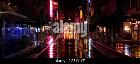 Melbourne City Bourke street mall tramlines on a wet night full of blurry reflections Stock Photo