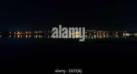 Nighttime street lights reflecting blurry streaks along the waterfront of Lake Wendouree in Ballarat Stock Photo