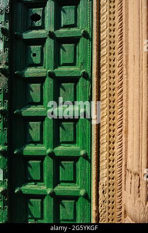 Old wooden green door with designer wall at varanasi (India) street Stock Photo