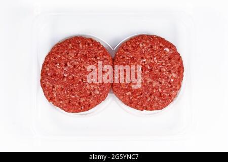 Two raw round burger patties in package on white background Stock Photo