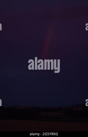 rainbow in red dusk clouds Stock Photo