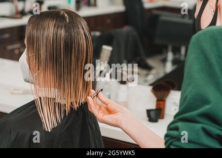 The hairdresser cuts the cut ends of the hair, wet hair in the barbershop, hair care during the quarantine period. new Stock Photo