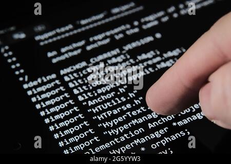 Blurred Finger touching tablet screen with the firts World Wide Web source code which was sold as NFT on auction. Selective focus. Concept. Stafford, Stock Photo