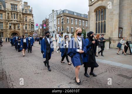 Picture dated June 30th 2021shows students from Trinity College Cambridge on their graduation day which has returned after the ceremony was cancelled last year due to the Coronavirus pandemic.  Students dressed in black gowns as the traditional Cambridge University graduation ceremonies took place – after they were cancelled last year due to the Coronavirus pandemic. The students paraded into historic Senate House to collect their degrees from the prestigious university. Family and friends would normally watch the ceremony inside the Senate House, but this year they had to wait outside due to Stock Photo