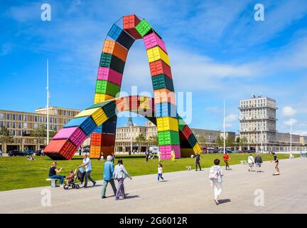 People strolling by the 'Catène de containers', an art installation made of two arches of containers in Le Havre, France. Stock Photo