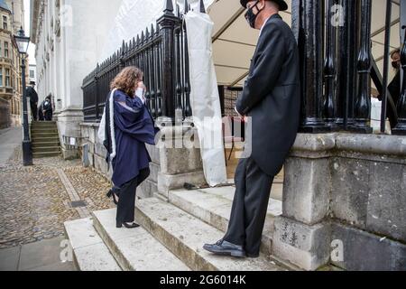 Picture dated June 30th 2021shows students from Trinity College Cambridge on their graduation day which has returned after the ceremony was cancelled last year due to the Coronavirus pandemic.  Students dressed in black gowns as the traditional Cambridge University graduation ceremonies took place – after they were cancelled last year due to the Coronavirus pandemic. The students paraded into historic Senate House to collect their degrees from the prestigious university. Family and friends would normally watch the ceremony inside the Senate House, but this year they had to wait outside due to Stock Photo