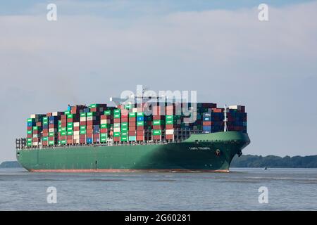 Stade, Germany - June 25, 2021: Container ship TAMPA TRIUMPH, owned by Costamare and operated by Evergreen Marine, on Elbe river heading to Hamburg Stock Photo