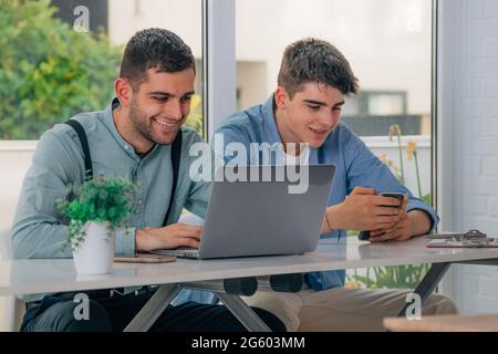 young people with computers and mobile phones at their desks Stock Photo