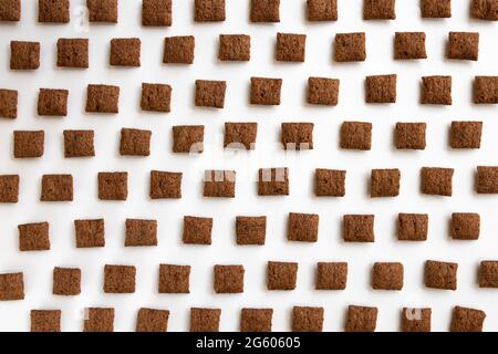 chocolate corn pads isolated on white background, food ingredient, chocolate corn cereal for breakfast, heap of sugar-coated corn flakes cutout, choco Stock Photo