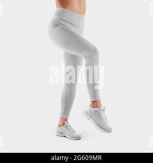 Woman in white tights and sneakers on gray background Stock