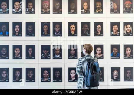 EDITORIAL USE ONLY A member of the public looks at an art installation called Portrait of Black Britain, by Cephas Williams, part of Manchester International Arts Festival.. Picture date: Thursday July 1, 2021. Stock Photo