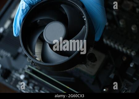 Gloved craftsman installing cooler into video card closeup Stock Photo