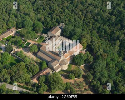 AERIAL VIEW. Centuries old Cistercian Abbey in a wooded secluded part of the Var Region. Le Thoronet, France. Stock Photo