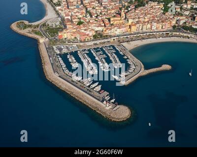 AERIAL VIEW. The marina of Menton and nearby, the colorful homes of the Old Town. French Riviera, Alpes-Maritimes, France. Stock Photo