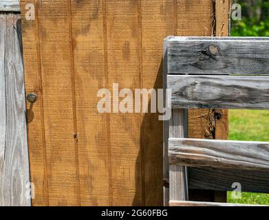 An old wooden door and weathered pallets make up the rustic fence that will house in the southwest Missouri flower garden. Lots of texture, lines and Stock Photo