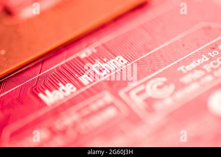 Close up image of a red printed circuit board with the words made china printed on it. Stock Photo
