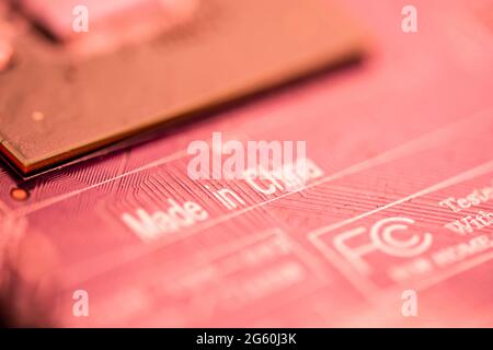 Close up image of a red printed circuit board with the words made china printed on it. Stock Photo