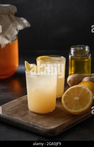 Homemade Kombucha with honey, lemon and ginger on black background. Heathy organic probiotic drink. Vertical format. Close up. Stock Photo