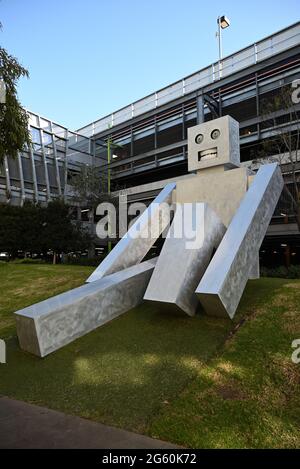 A sculpture of a humanoid robot called Dayton, created by Ronnie van Hout, on display beside a car park at Monash University's Clayton Campus Stock Photo