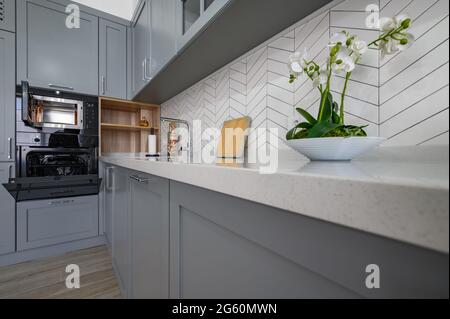 Closeup to corner of grey and white modern kitchen furniture Stock Photo