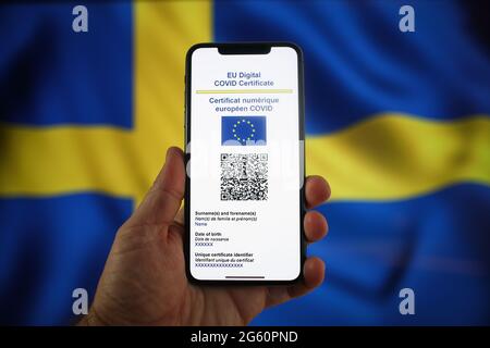 Warsaw, Pl. 01st July, 2021. An EU COVID certificate is seen on a mobile device in with a Swedish flag in the background in this photo illustartion in Warsaw, Poland on July 1, 2021. The EU COVID certificate, a document in digital or analogue form that allows fully vaccinated people to travel to all 27 EU member states has become avaialbe since July 1. (Photo by Jaap Arriens/Sipa USA) Credit: Sipa USA/Alamy Live News Stock Photo