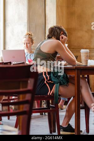 NEW ORLEANS, LA, USA - JUNE 13, 2021: Young women studying in coffee shop Stock Photo