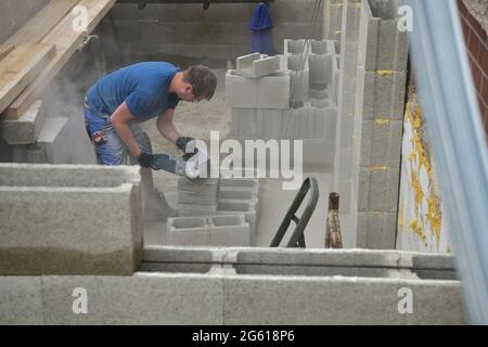 Brick wall made of blocks and sawing a hole in a window made of blocks using a grinder Stock Photo