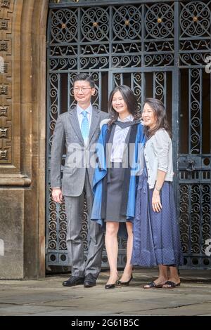 A female student poses for a photograph with her parents on her graduation day at Gonville and Caius college, university of Cambridge, England. Stock Photo