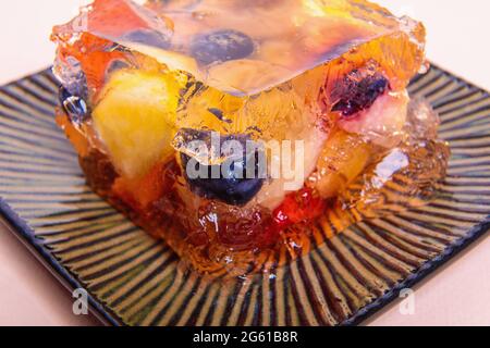 Jelly from different fruits and berries on a square saucer. Dessert. Close-up Stock Photo