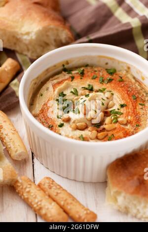 Close up of hummus with pine nuts and fresh bread Stock Photo
