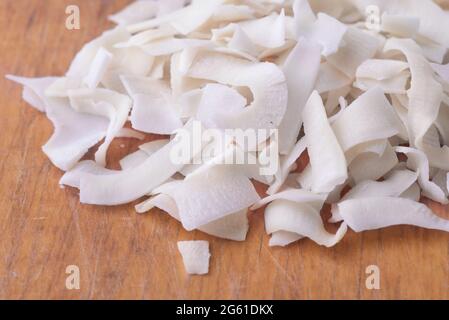Close up of organic coconut chips on old wooden background Stock Photo