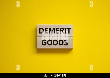 Demerit goods symbol. Wooden blocks with words Demerit goods on beautiful yellow background, copy space. Business and demerit goods concept. Stock Photo