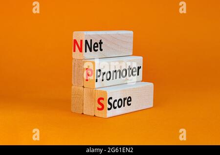 NPS net promoter score symbol. Wooden blocks with words 'NPS net promoter score'. Beautiful orange background. Business and NPS net promoter score con Stock Photo