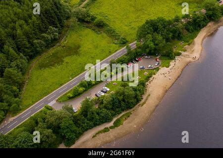 Loch Lubnaig, Loch Lomonnd and Trossachs National Park, Scotland, UK. 1st July, 2021. PICTURED: Drone aerial view looking down from above of Loch Lubnaig car park showing overcrowding of vehicles which are not parked outwith designated parking areas, blocking up the turning circle for cars looking to exit the car park, despite the signs advising against this practice. The beach is wider than normal due to the low water levels in the loch. Credit: Colin Fisher/Alamy Live News Stock Photo