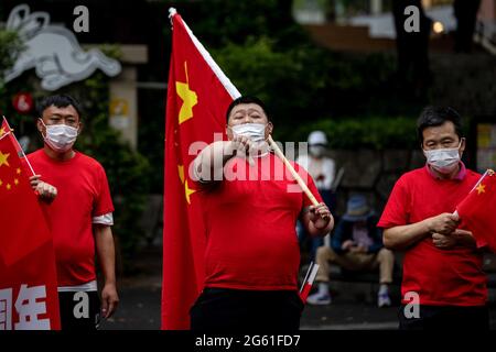A pro-Beijing supporter with a Chinese flag gestures during a pro CCP rally.1st of July marks the 100th anniversary of the founding of the CCP (Chinese Communist Party) and the 24th anniversary of Hong Kong's handover to China. CCP supporters took to the street to celebrate while pro democracy Hong Kong protestors also march through the capital city to express their politic stands. (Photo by Viola Kam / SOPA Images/Sipa USA) Stock Photo