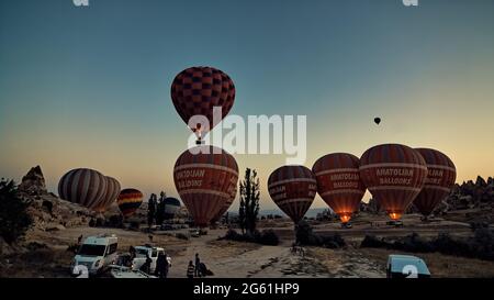 hot air balloons at sunrise before the flight above the fairy chimneys in the sky of Cappadocia in Turkey Stock Photo