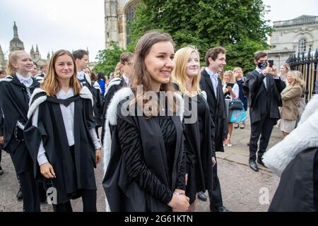 Picture dated  July 1st 2021 shows students from  Queens’  Cambridge on their graduation day which has returned after the ceremony was cancelled last year due to the Coronavirus pandemic.  Students dressed in black gowns as the traditional Cambridge University graduation ceremonies took place – after they were cancelled last year due to the Coronavirus pandemic. The students paraded into historic Senate House to collect their degrees from the prestigious university. Family and friends would normally watch the ceremony inside the Senate House, but this year they had to wait outside due to Covid Stock Photo