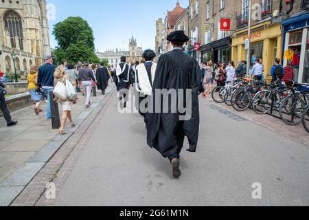 Picture dated  July 1st 2021 shows students from  Queens’  Cambridge on their graduation day which has returned after the ceremony was cancelled last year due to the Coronavirus pandemic.  Students dressed in black gowns as the traditional Cambridge University graduation ceremonies took place – after they were cancelled last year due to the Coronavirus pandemic. The students paraded into historic Senate House to collect their degrees from the prestigious university. Family and friends would normally watch the ceremony inside the Senate House, but this year they had to wait outside due to Covid Stock Photo