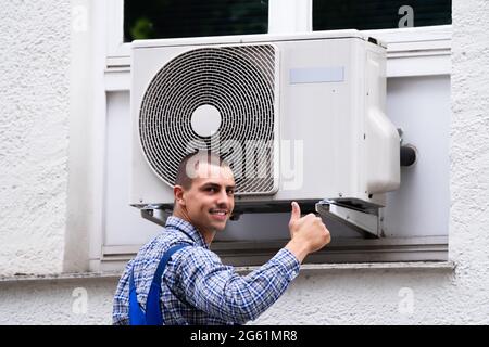 Technician Cleaning And Repairing Air Condition Appliance. AC Unit Maintenance Stock Photo