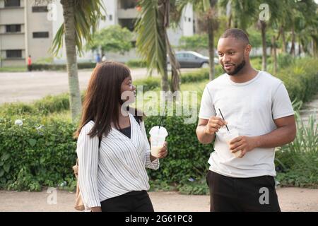 young people taking cups of smoothie outdoor,young people chilling outdoor Stock Photo