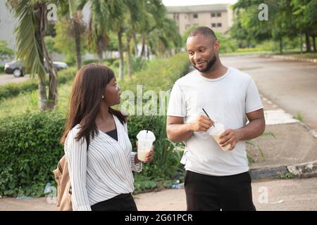 young people taking cups of smoothie outdoor,young people chilling outdoor Stock Photo