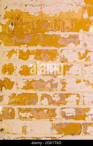 Yellow faded paint on white brick forms abstract background pattern Stock Photo