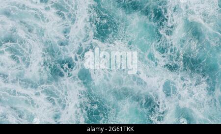 3D rendering of a top view of turquoise waves with foam. Water splash in the sea, ocean on a bright sunny day