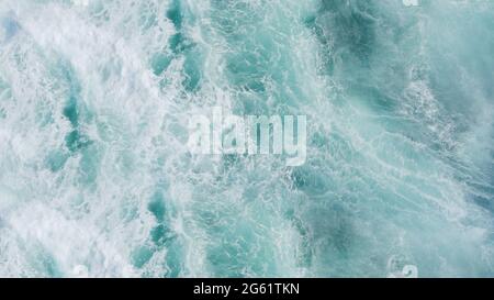 3D rendering of a top view of turquoise waves with foam. Water splash in the sea, ocean on a bright sunny day