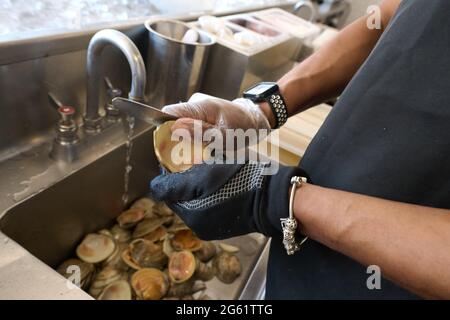 Brooklyn, New York, USA. 30th June, 2021. Person shucking fresh clams. Brooklyn, New York. 20210630. NEW Credit: Edna Leshowitz/ZUMA Wire/Alamy Live News Stock Photo