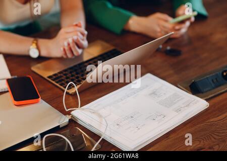 Architect top view of female hands laptop notebook drawings and phone. Stock Photo