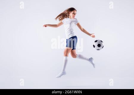 Full length body size view of nice attractive lovely slim sportive qualified cheerful straight-haired girl jumping running playing throwing ball Stock Photo