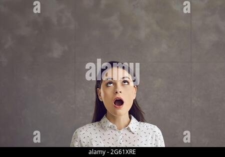Young caucasian woman with opened mouth looking up feeling shock emotion Stock Photo