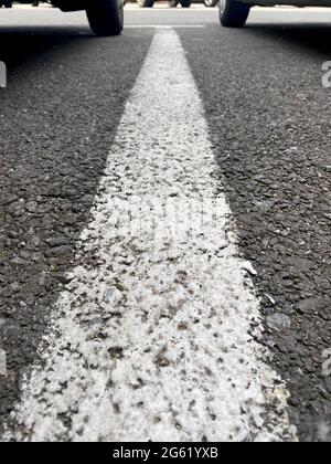 White parking lane line with two wheels on background Stock Photo